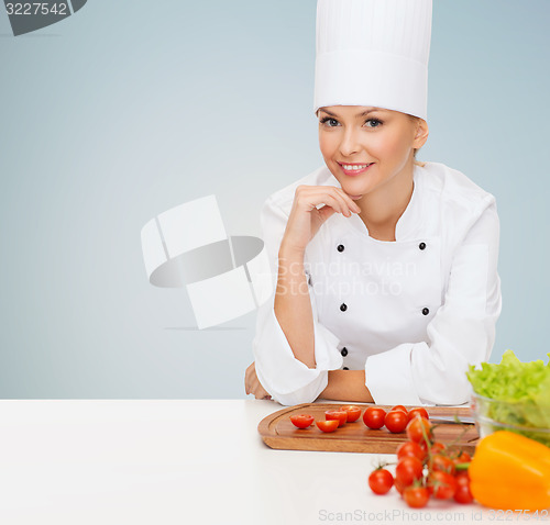 Image of smiling female chef with vagetables