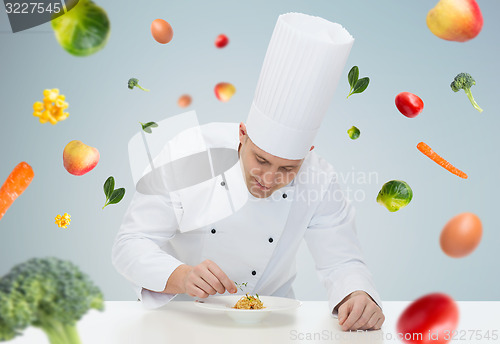 Image of happy male chef cook decorating dish