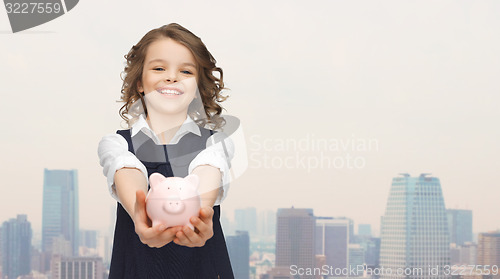 Image of happy girl holding piggy bank on palms