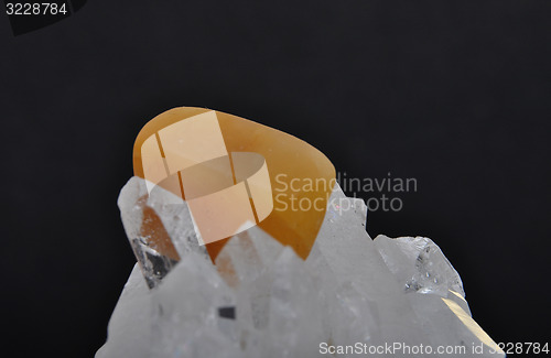 Image of Orange calcite on rock crystal