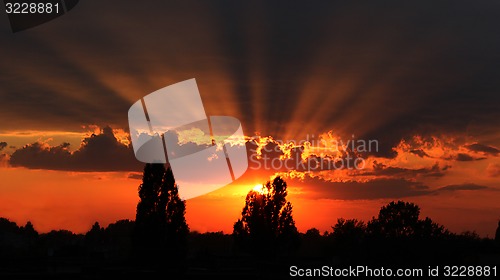 Image of beautiful summer sunset with dark sky and sun
