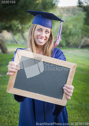Image of Woman Holding Diploma and Blank Chalkboard Wearing Cap and Gown