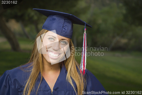 Image of Young Woman Wearing Cap and Gown Outdoors