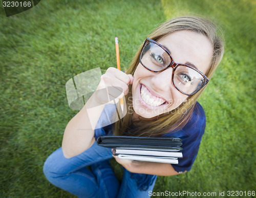 Image of Wide Angle of Pretty Young Woman with Books and Pencil