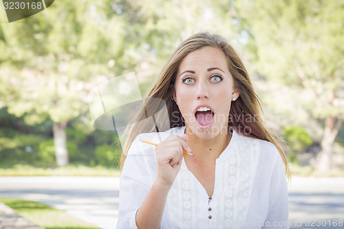 Image of Excited Young Woman With Pencil Outdoors
