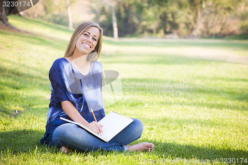Image of Portrait of a Beautiful Young Woman With Book Outdoors