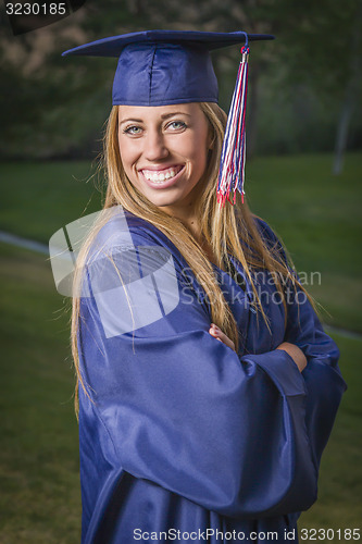 Image of Young Woman Wearing Cap and Gown Outdoors