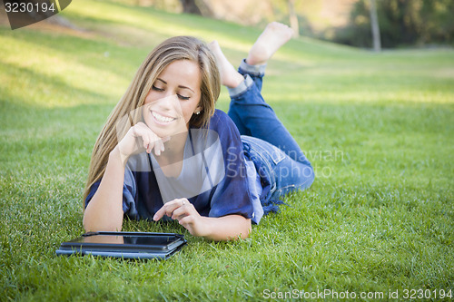 Image of Smiling Young Woman Using Computer Tablet Outdoors