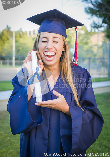 Image of Expressive Young Woman Holding Diploma in Cap and Gown