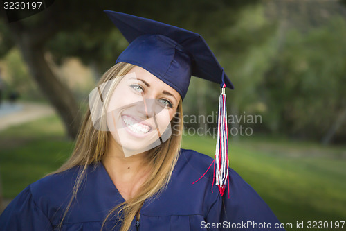 Image of Young Woman Wearing Cap and Gown Outdoors