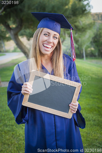 Image of Woman Holding Diploma and Blank Chalkboard Wearing Cap and Gown