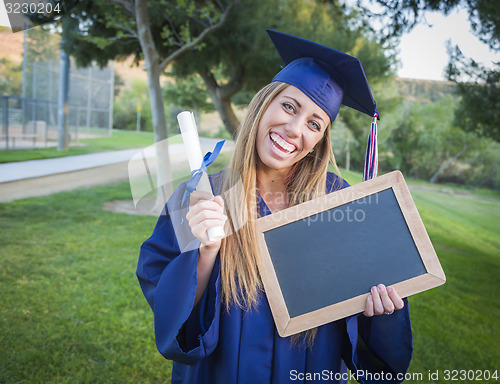 Image of Woman Holding Diploma and Blank Chalkboard Wearing Cap and Gown