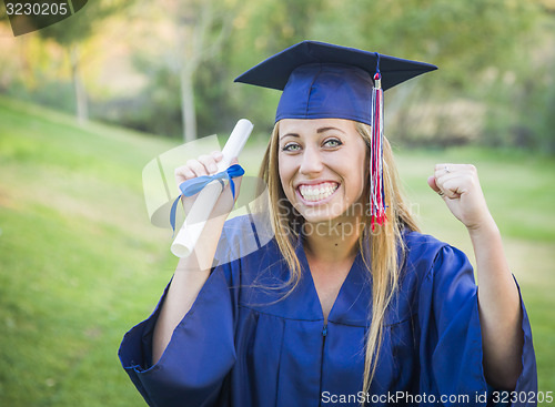 Image of Expressive Young Woman Holding Diploma in Cap and Gown