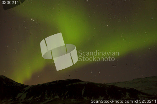 Image of Northern lights with snowy mountains in the foreground