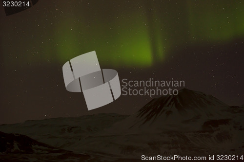 Image of Northern lights with snowy mountains in the foreground