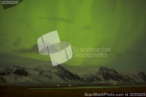 Image of Northern lights with snowy mountains in the foreground