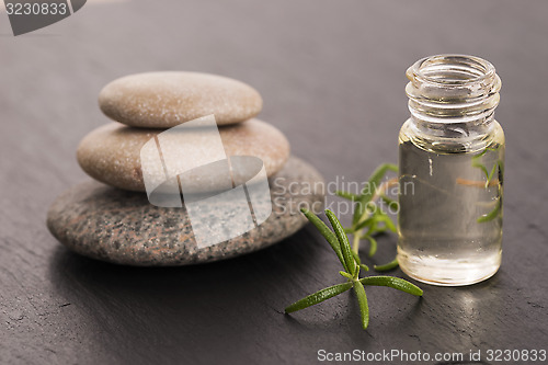 Image of Essential oil with rosemary and fresh green leaves 