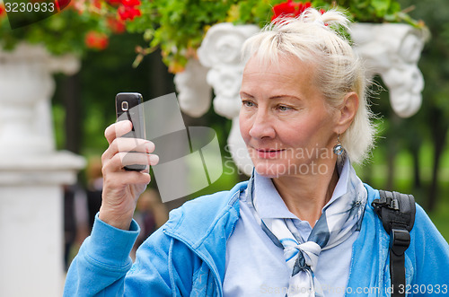 Image of  woman photographed in a park on the phone  