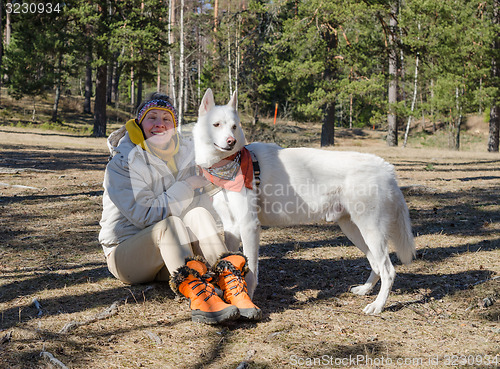 Image of Woman with a white dog in a wood