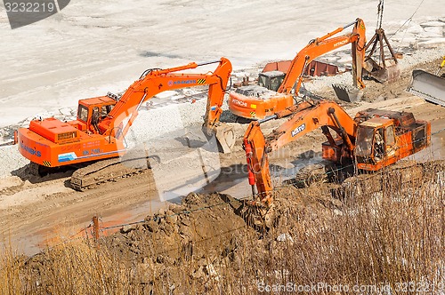 Image of Excavators on pedestrian quay construction. Tyumen