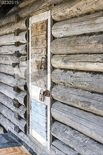 Image of Old wooden door locked with padlock