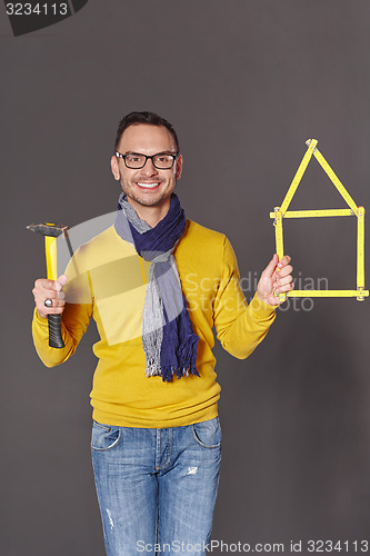 Image of Man with hammer showing house frame concept