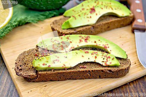 Image of Sandwich with avocado and pepper on dark board