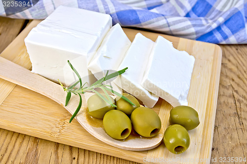 Image of Feta with olives and rosemary in spoon on board