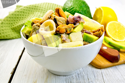 Image of Salad seafood and avocado in bowl on light board