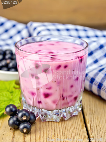 Image of Milkshake with black currants in glass on board