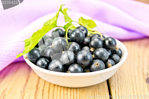 Image of Black currants in bowl with napkin on board