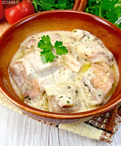 Image of Fish stew in sauce on ceramic pan with tomatoes