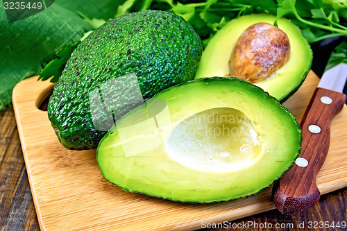 Image of Avocado with knife on board