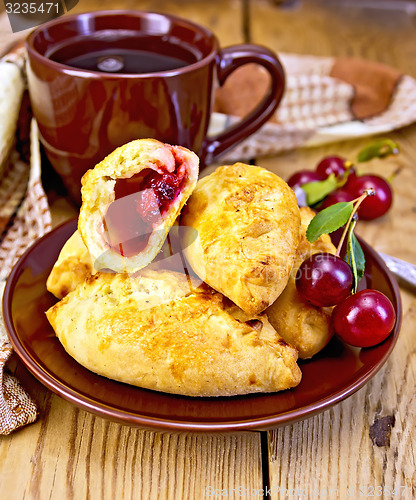 Image of Pies with cherry and mug on board