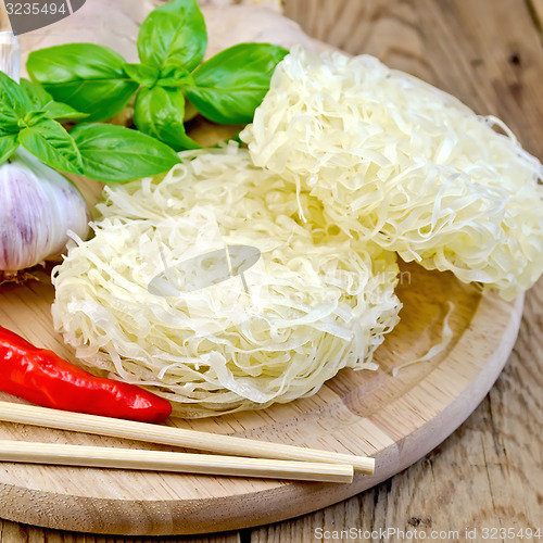 Image of Noodles rice twisted with spices and basil on board