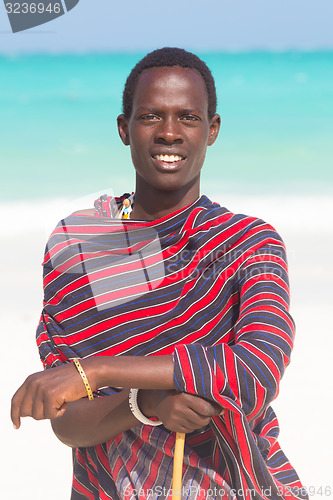 Image of Traditonaly dressed black man on beach. 