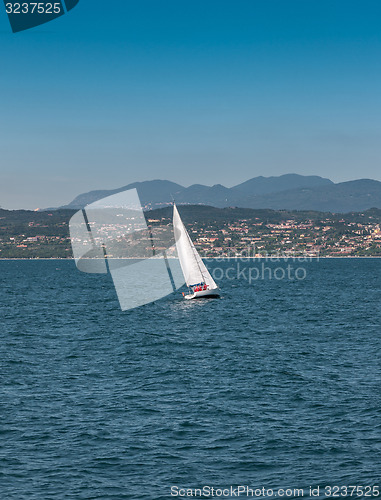 Image of Sail boat on a lake with mountains as background