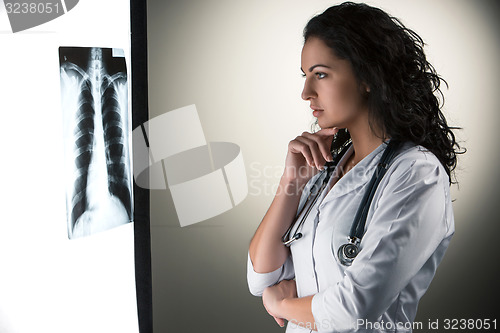 Image of Image of attractive woman doctor looking at x-ray results