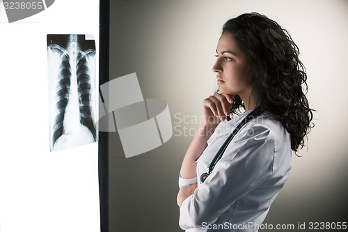 Image of Image of attractive woman doctor looking at x-ray results