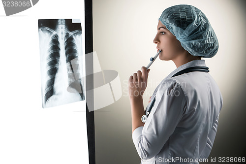 Image of Image of attractive woman doctor looking at x-ray results