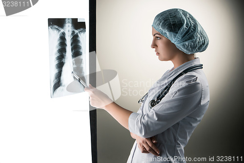 Image of Image of attractive woman doctor looking at x-ray results