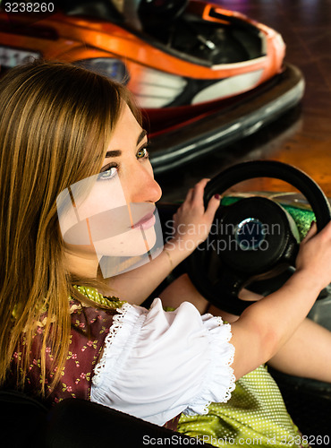 Image of Beautiful girl in an electric bumper car in amusement park