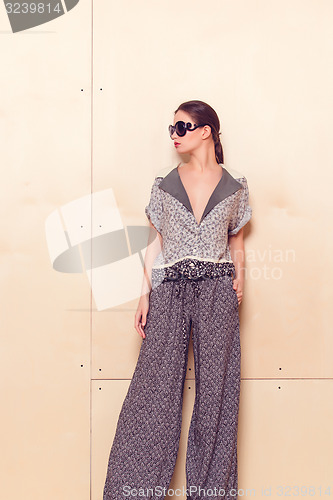 Image of Full height portrait of a young woman in pantsuit