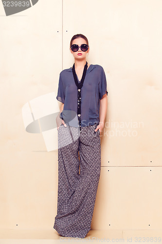 Image of Full height portrait of a young woman in pantsuit