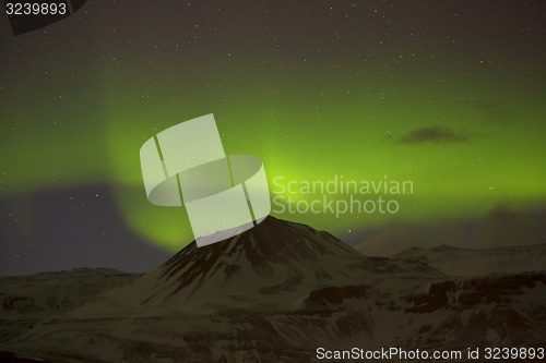 Image of Northern lights with snowy mountains in the foreground