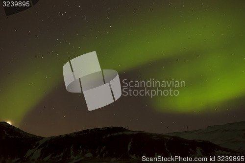 Image of Northern lights with snowy mountains in the foreground