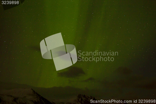 Image of Northern lights with snowy mountains in the foreground