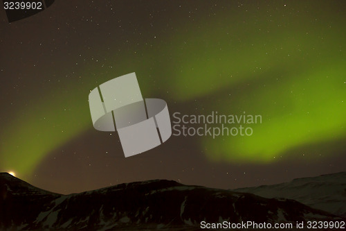 Image of Northern lights with snowy mountains in the foreground