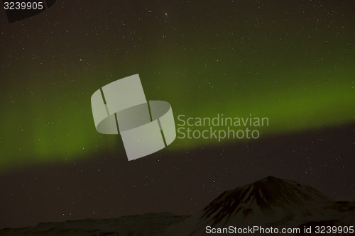 Image of Northern lights with snowy mountains in the foreground