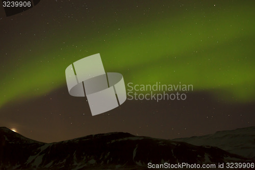 Image of Northern lights with snowy mountains in the foreground